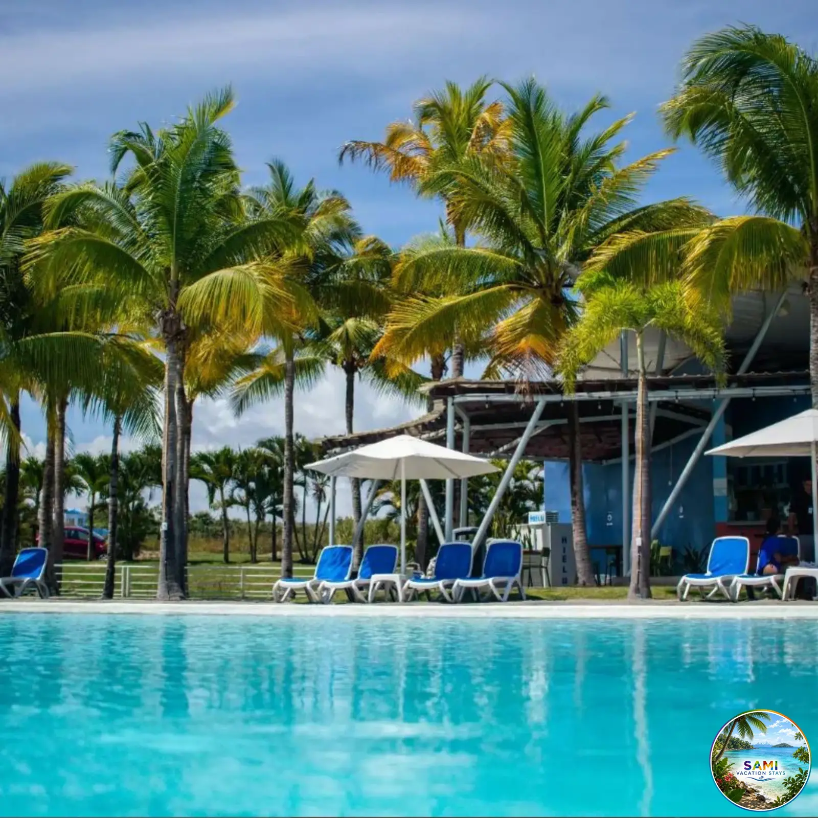 Resort pool with lounge chairs and palm trees