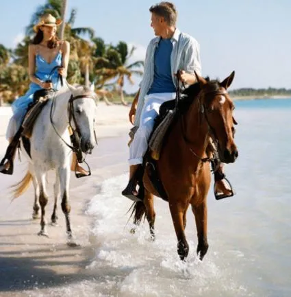 Couple à cheval le long d'une plage du Panama
